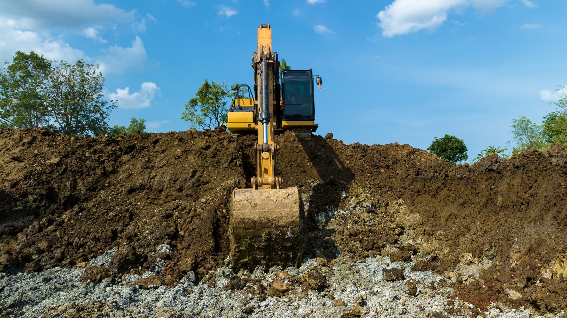 excavating soil into a dump truck to build a pond for store water for use in the dry season for agriculture